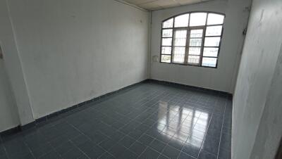 Empty room with tiled flooring and large window