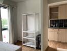 Cozy bedroom with open wardrobe and adjacent kitchenette