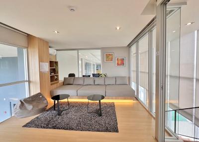 Modern living room with ample natural light and contemporary furnishings