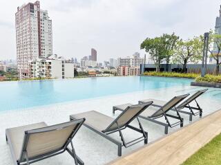 Luxurious outdoor swimming pool with lounge chairs and city view