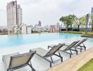 Luxurious outdoor swimming pool with lounge chairs and city view