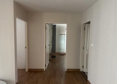 Bright and spacious hallway with hardwood floors and multiple doors leading to rooms