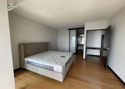 Spacious bedroom with a large bed and hardwood floors