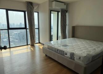 Spacious bedroom with large windows and city view