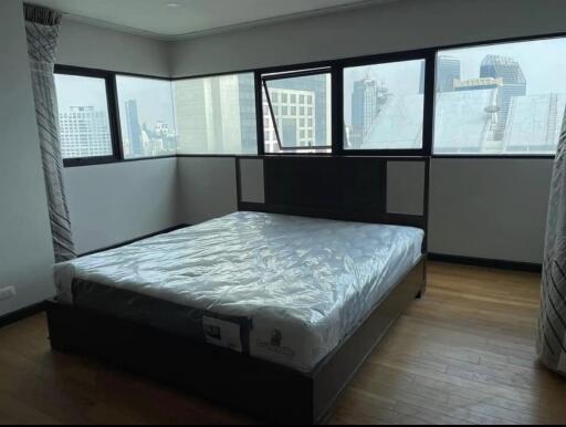 Spacious bedroom with large windows and city view