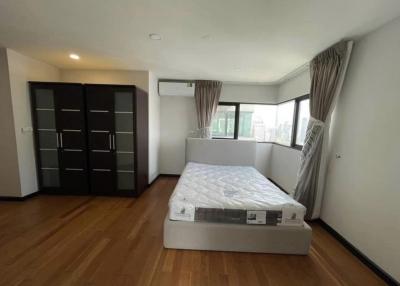 Spacious bedroom with hardwood floors and plenty of natural light