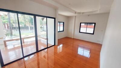 Spacious living room with large windows and hardwood floors