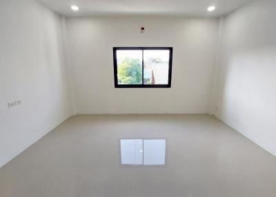 Empty bedroom with white walls and grey floor