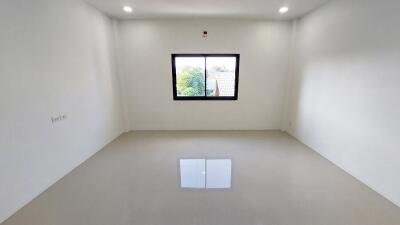 Empty bedroom with white walls and grey floor