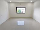 Empty bedroom with white walls and grey floor