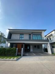 Modern two-story house with large windows and garden