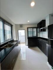 Modern kitchen with black cabinets and white flooring