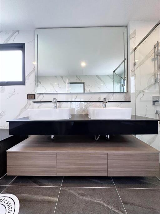 Modern bathroom with dual sinks and marble tiling