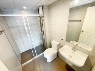 Modern bathroom with glass shower enclosure, toilet, and sink