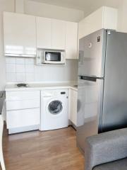 Modern kitchen with stainless steel appliances and washing machine