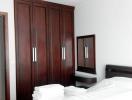 Modern bedroom with dark wood furniture and white bedding