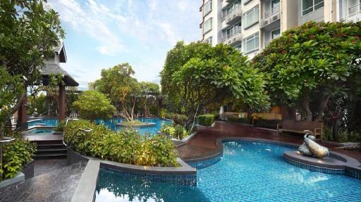 Luxurious outdoor swimming pool area with lush greenery in a residential building