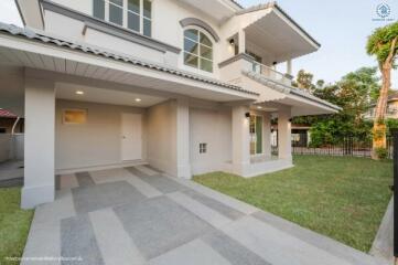 Elegant two-story house with a spacious carport and manicured lawn