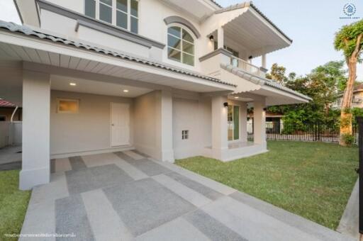 Elegant two-story house with a spacious carport and manicured lawn