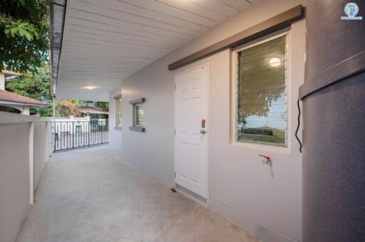 Well-lit home entrance with white front door and windows