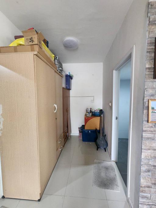 Narrow hallway with storage cabinets and tiled flooring