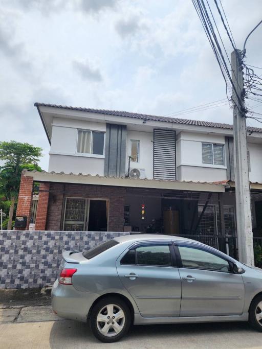 Two-story residential building with a car parked in front