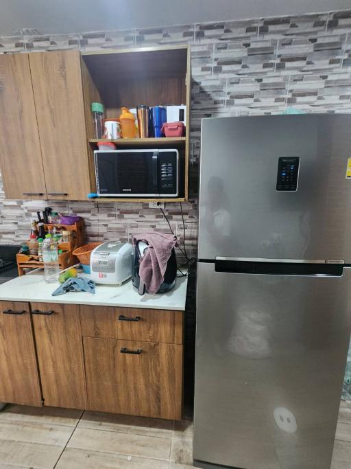 Modern kitchen with wooden cabinets and stainless steel refrigerator