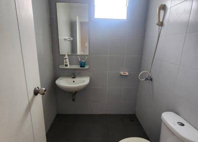 Compact bathroom with window, sink, and toilet