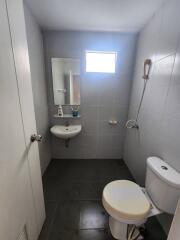 Compact bathroom with window, sink, and toilet