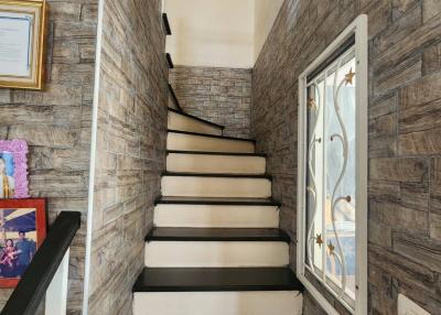 A narrow staircase with stone-patterned wallpaper