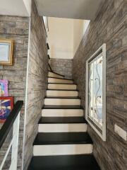 A narrow staircase with stone-patterned wallpaper