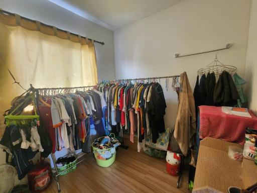 Cluttered bedroom with clothes and personal items