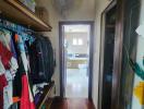 View of a bedroom closet leading towards an en-suite bathroom