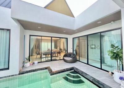Spacious living area with pool and ample natural light