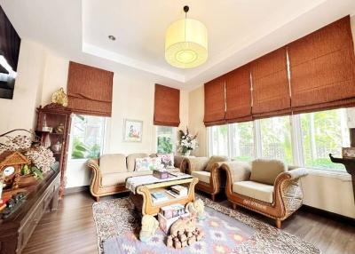 Spacious and well-lit living room with large windows and comfortable seating