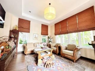 Spacious and well-lit living room with large windows and comfortable seating