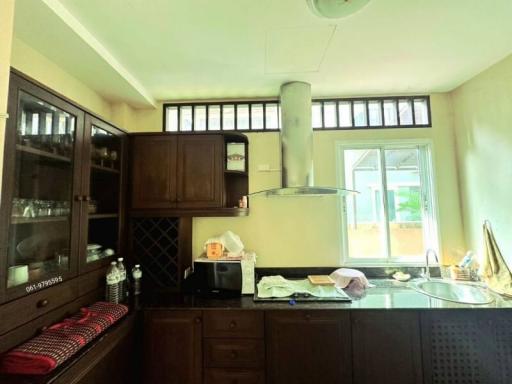 Spacious kitchen with wooden cabinets and large windows