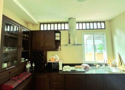 Spacious kitchen with wooden cabinets and large windows