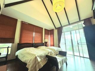 Spacious bedroom with modern decor, natural light, and a balcony