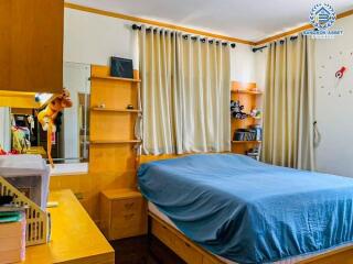 Well-lit cozy bedroom with wooden furniture