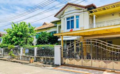 Elegant two-story house with a balcony and gated entrance