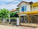 Elegant two-story house with a balcony and gated entrance