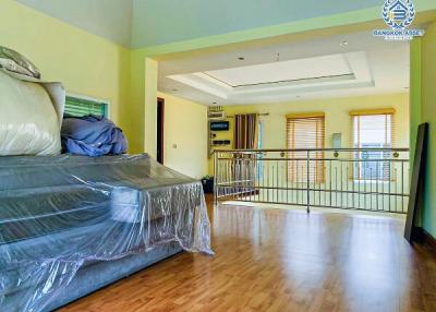 Spacious upper floor bedroom with hardwood flooring and natural light
