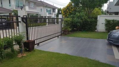 Spacious front yard with driveway and sliding gate