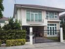 Two-storey residential house with a balcony and driveway