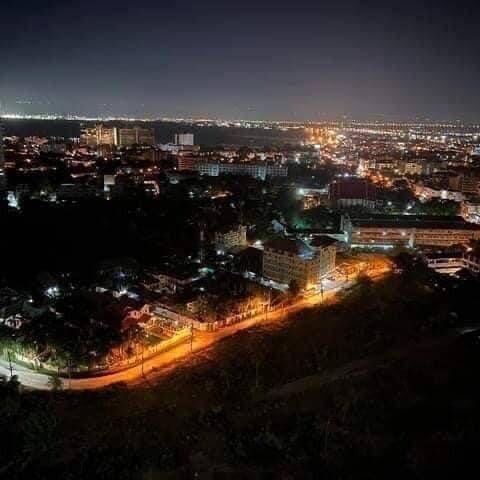 Panoramic night view of a cityscape with illuminated buildings and streets