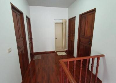 Spacious hallway with hardwood flooring and multiple wooden doors