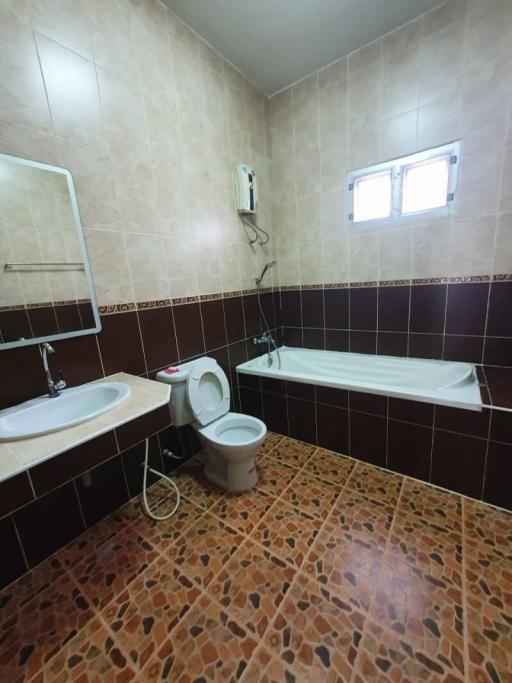 Spacious bathroom with bathtub and tiled finish