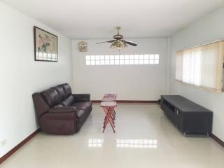 Spacious living room with minimalist decor, large sofa, and ample natural light