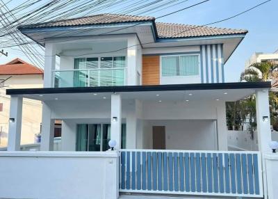 Modern two-story house with a balcony and covered parking area